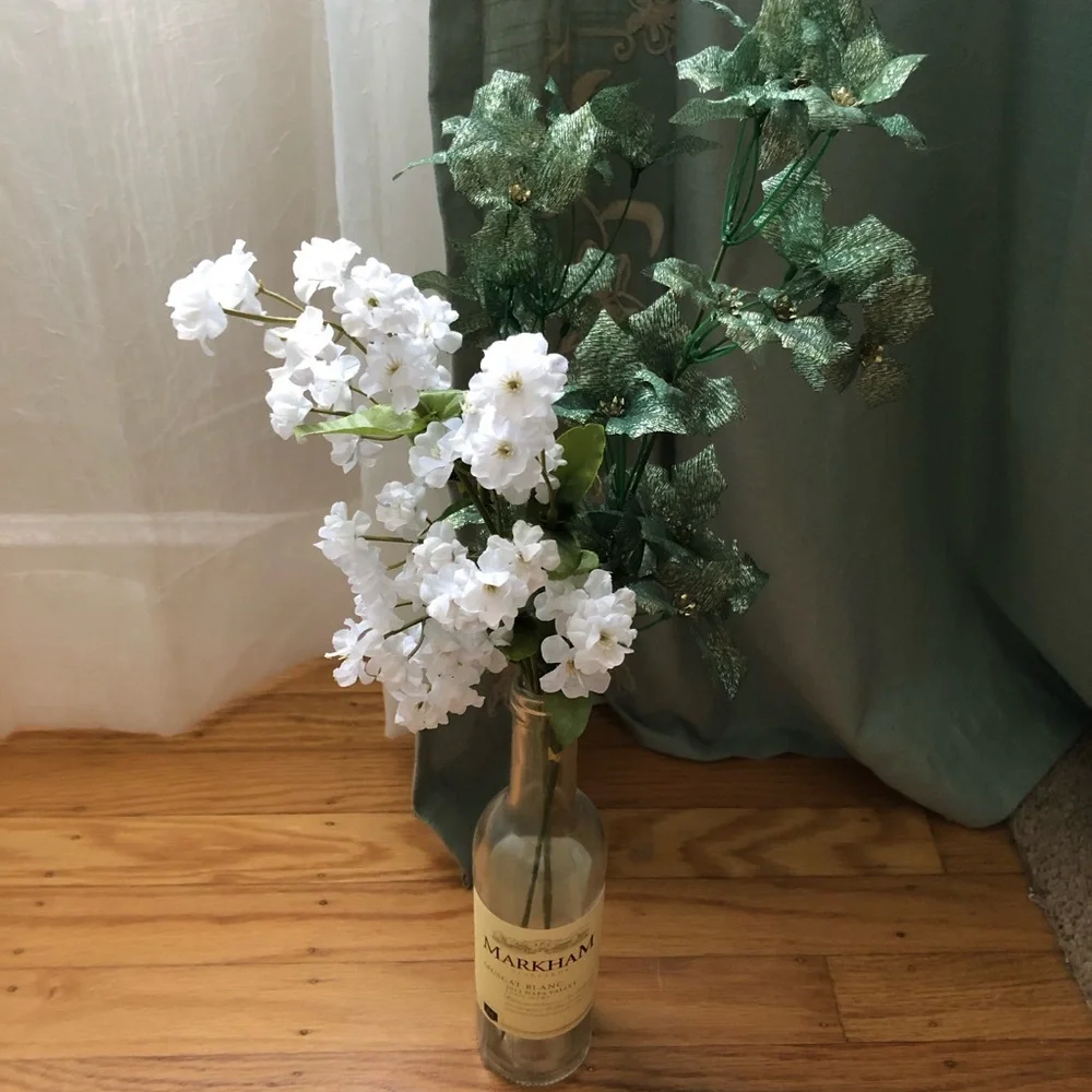 Faux floral with leaves in wine bottle